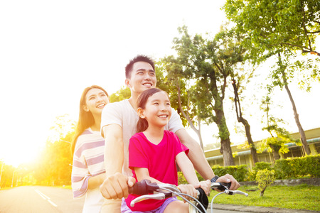 Happy asian family having fun in park with bicycleの写真素材