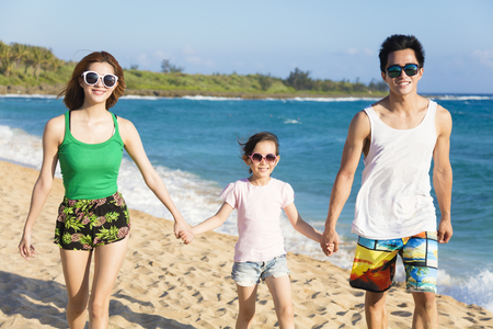 happy young family walking on the beachの写真素材