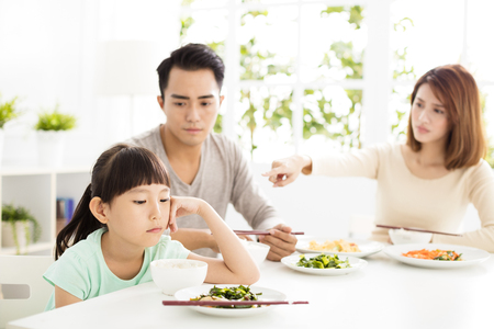 child refuses to eat while family dinnerの写真素材