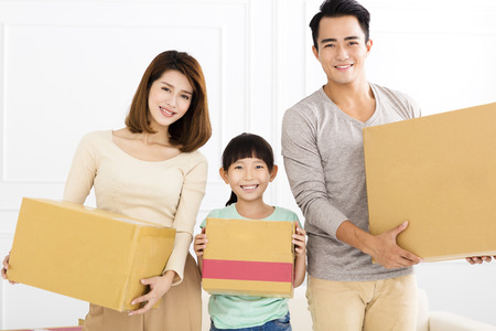 happy family holding box moving to new home