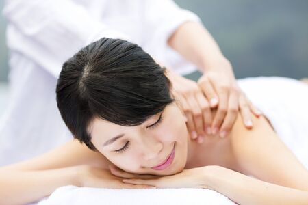 young woman in spa salon getting massageの写真素材