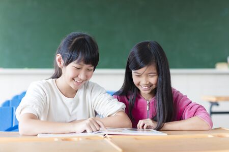 Two teenage girls student study in classroomの写真素材