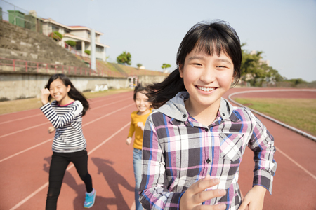 happy teenager girls running on the trackの写真素材