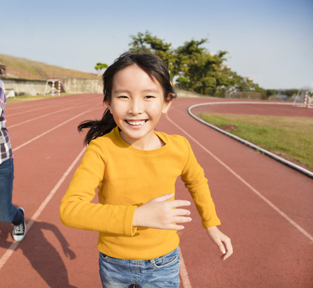 happy little girls running on the trackの写真素材