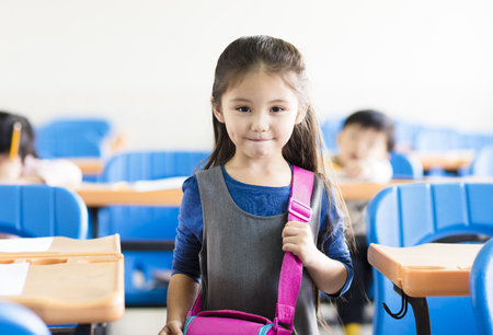 happy little girl student  in the classroomの写真素材