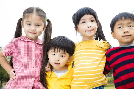 Group of smiling kids standing outside togetherの写真素材