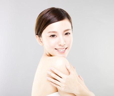 young smiling woman face with gray backgroundの写真素材