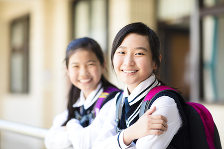 Two smiling pretty student girls  in schoolの写真素材
