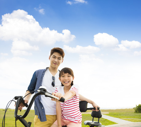 happy father with daughter riding bicycle  outdoorsの写真素材