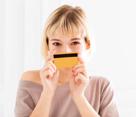 Smiling young woman showing credit cardの写真素材