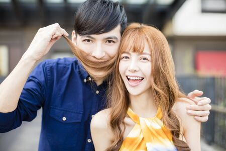 happy couple using hair as moustache