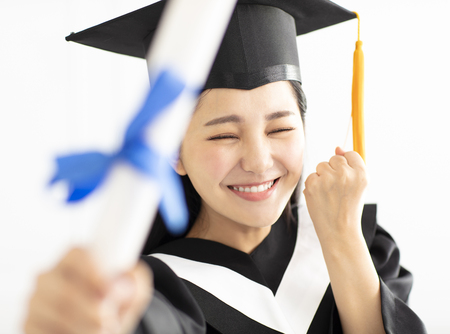 Happy Graduation girl In Cap and Gown Celebrating の写真素材