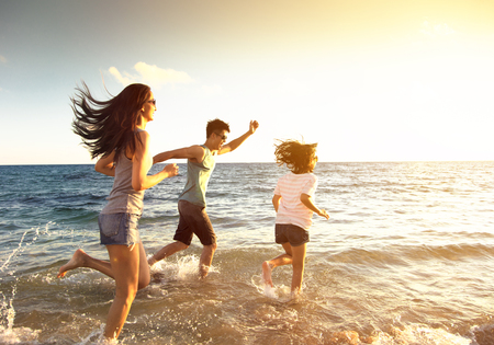 happy family running on the beachの写真素材