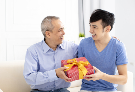 happy family celebrating and son giving gift to fatherの写真素材