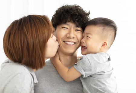 happy family mother, father and child kissingの写真素材