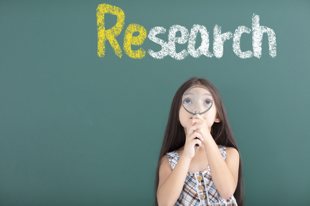 amazing girl holding Magnifying Glass with research conceptの写真素材