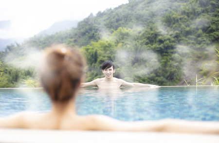 Young asian couple relaxing in hot springs