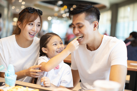 Happy family  enjoying dinner in restaurant.の写真素材