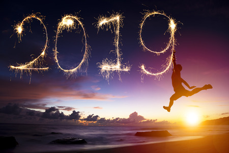 Happy new year 2019. Man jumping and drawing on beachの写真素材