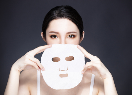 Young woman holding a facial maskの写真素材