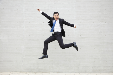 excited Young businessman running and jumpingの写真素材