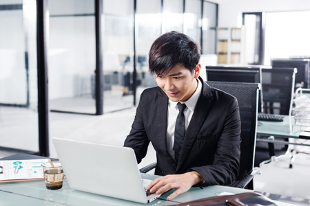 young businessman working with laptop in officeの写真素材
