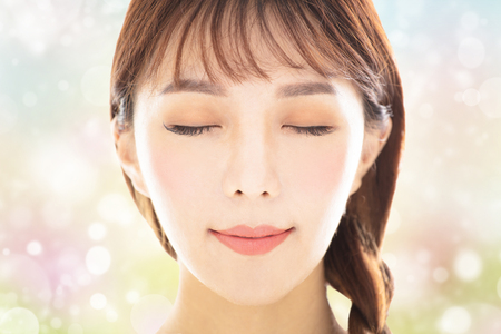 closeup young smiling beauty face with spring backgroundの写真素材