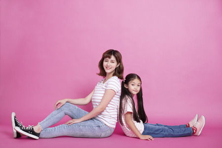 happy mother and daughter sitting togetherの写真素材