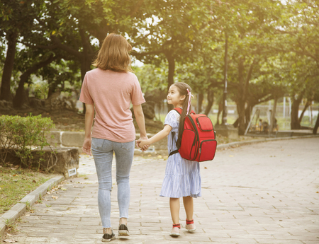 Mother and child holding hands going to schoolの写真素材
