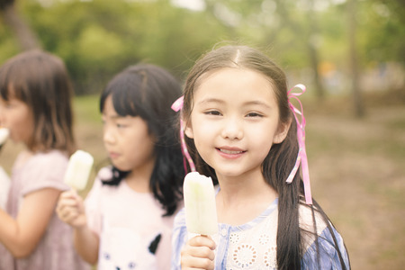 happy children eating ice cream stick at summertimeの写真素材