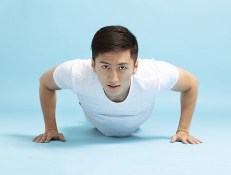 Portrait of young fitness man doing push upの写真素材