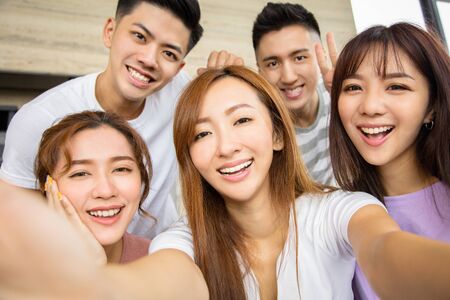 Close up of five excited friend taking selfie photoの写真素材