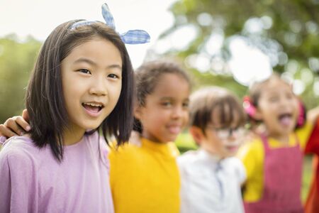 Multi-ethnic group of school children laughing and embracingの写真素材