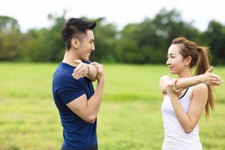 Young sporty couple working out together outdoorsの写真素材