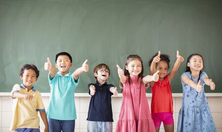 Multi-ethnic group of school children standing in classroomの写真素材