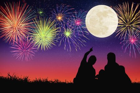 happy family sitting on hill and watching the moon and fireworks.Celebrate Mid-autumn festival の写真素材