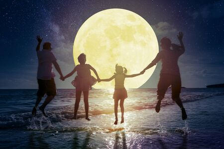 family jumping on beach and watching the moon.Celebrate Mid autumn festival conceptの写真素材