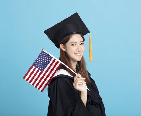 happy Young female graduation student showing the USA flagの写真素材