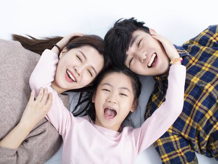 happy family lying on floor looking at cameraの写真素材