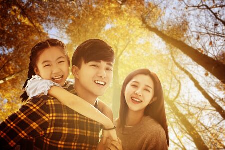 happy asian family  with autumn leaves backgroundの写真素材