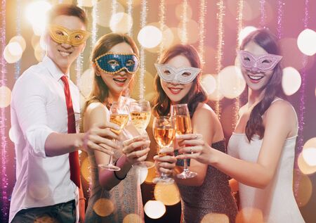 happy young group celebrating New Year and drinking champagne on masquerade partyの写真素材