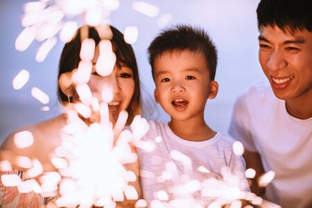happy family celebrating new year with sparklers