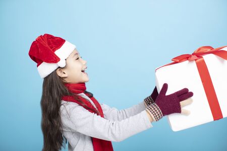 happy little girl in Santa hat and  holding gift boxの写真素材
