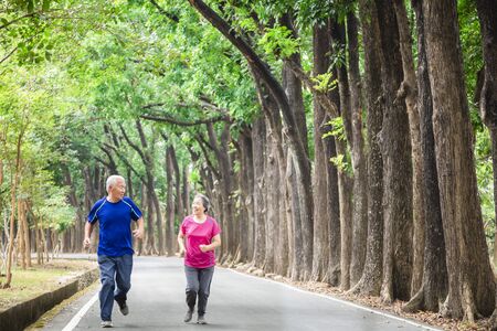 happy asian Senior couple running outside at parkの写真素材