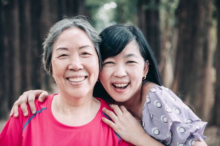 asian senior mother and her adult daughter are huggingの写真素材