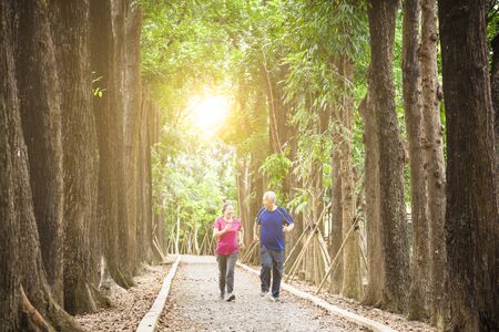 happy asian senior couple jogging together at morningの写真素材