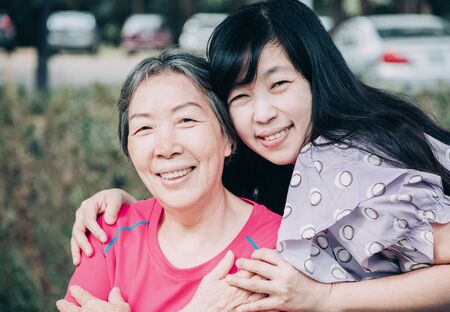 asian senior mother and her adult daughter are huggingの写真素材