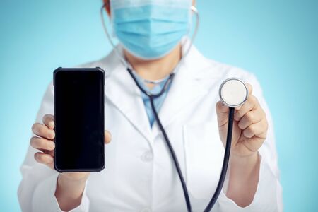 doctor with stethoscope and smart phone in hand for medical exam conceptsの写真素材