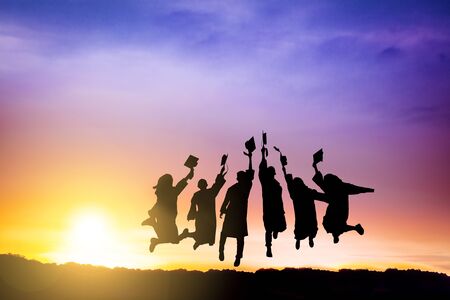 The Silhouette of  graduation group celebrating and jumping on mountainの写真素材