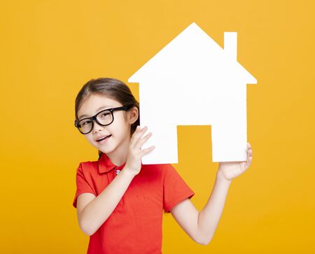 happy little girl showing and  holding house modelの写真素材